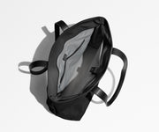 Unzipped and unpacked Everywhere Tote bag, showing the interior zip pockets, slip pockets, and laptop pocket