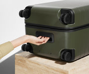 The Trunk suitcase in Olive Green shown from below highlighting the underside grab handle