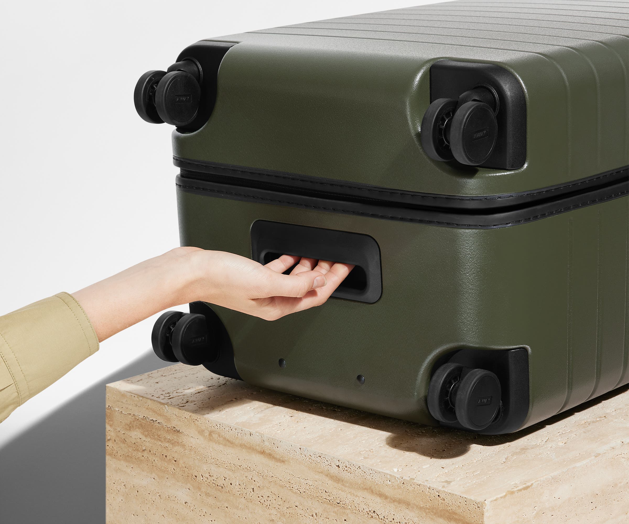 The Trunk suitcase in Olive Green shown from below highlighting the underside grab handle