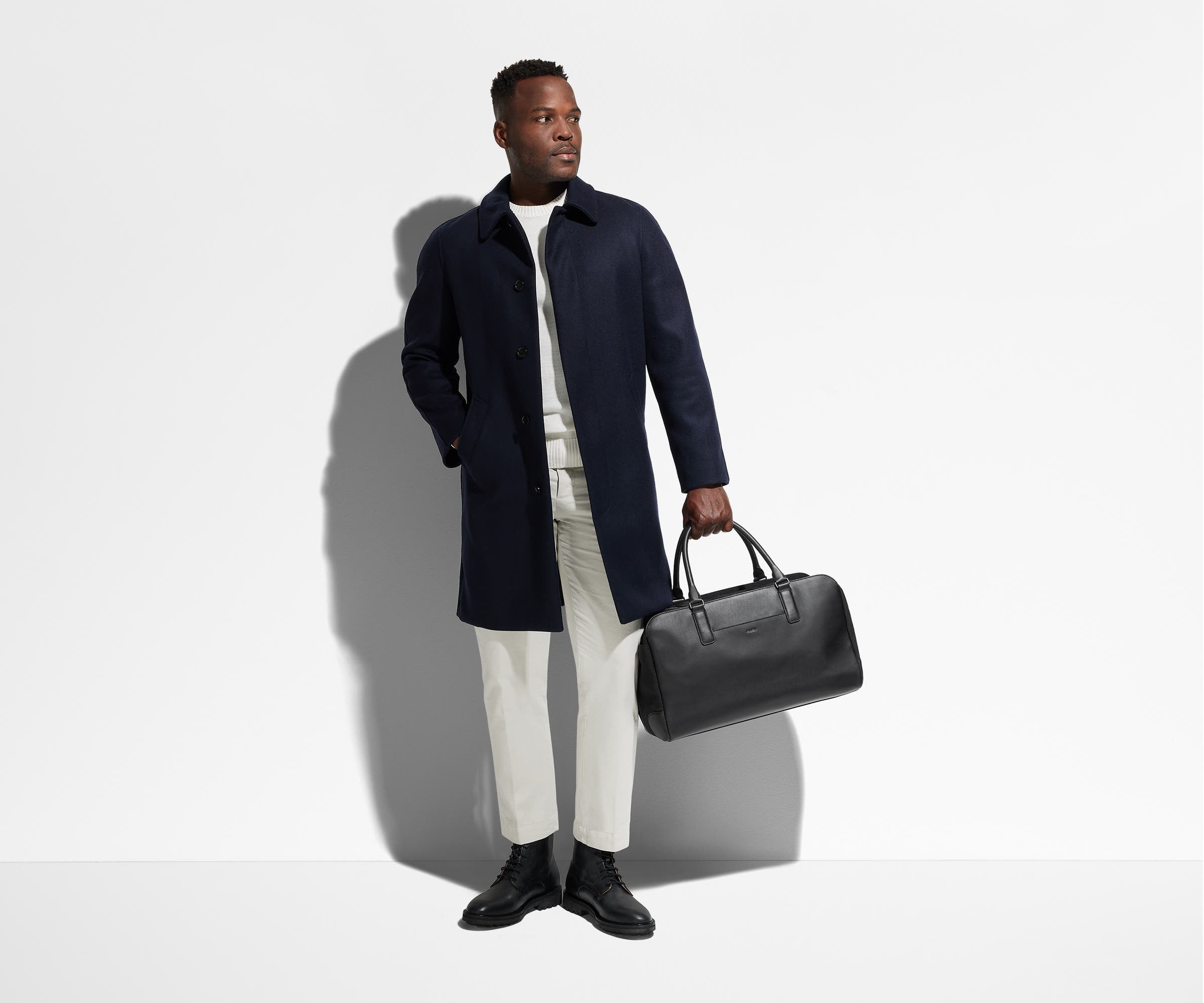 Person holding the Transit Leather Duffle by its top handles