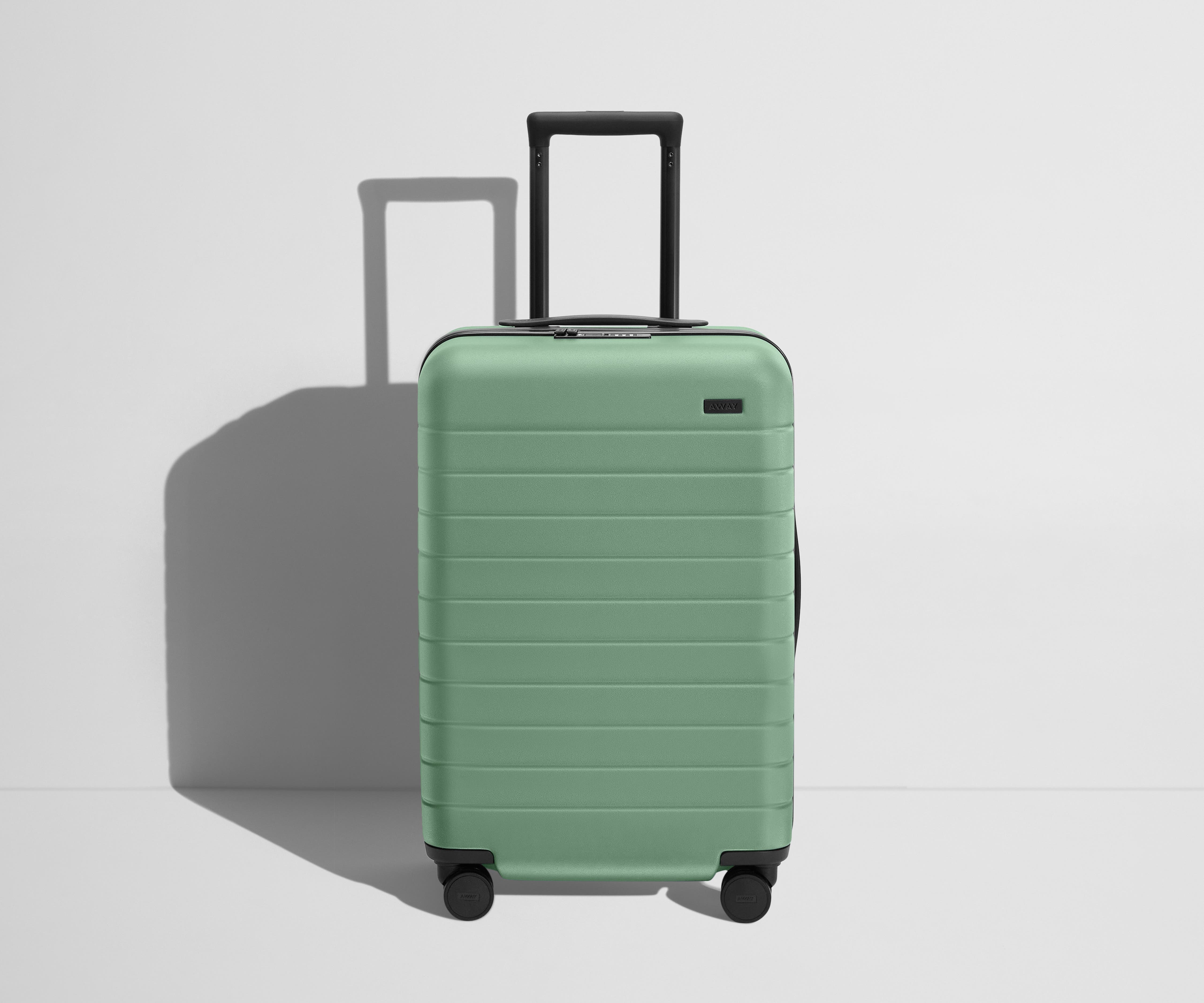 Front product view of The Bigger Carry-On Flex suitcase in Sea Green with raised handle