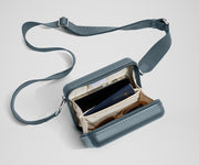 The Mini Crossbody packed with a phone, passport, and sunglasses