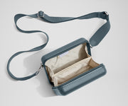 Unzipped, open view of The Mini Crossbody, showing the two main compartments and slip pocket