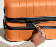 The Bigger Carry-On Flex suitcase in Sorbet Orange has an additional wraparound zipper to expand the suitcase 2.25" (6 cm) and increase packing space