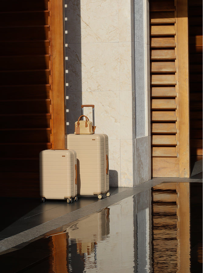 A set of Away x White Lotus luggage next to a pool at a hotel