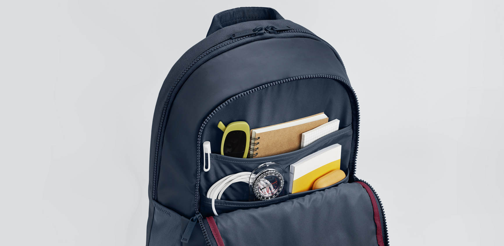 A close up shot of an Away Active backpack open to show the interior organization of the front pocket