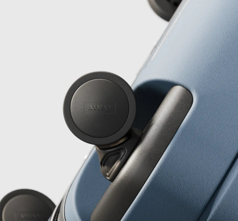 Close crop of a wheel on a blue Away suitcase