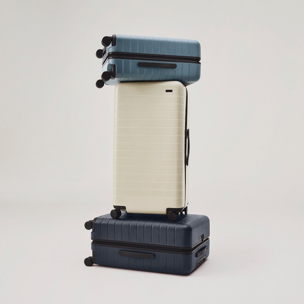 Three suitcases stacked on top of each other on a white background