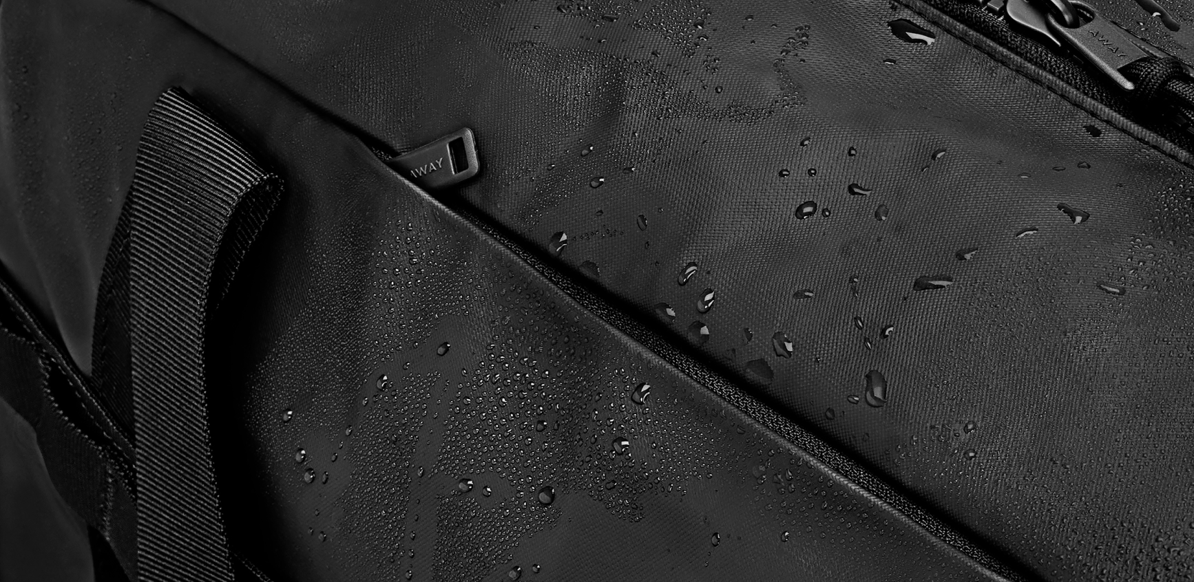 A close up of the Away Active duffle with water on the outside material showing it's water resistant