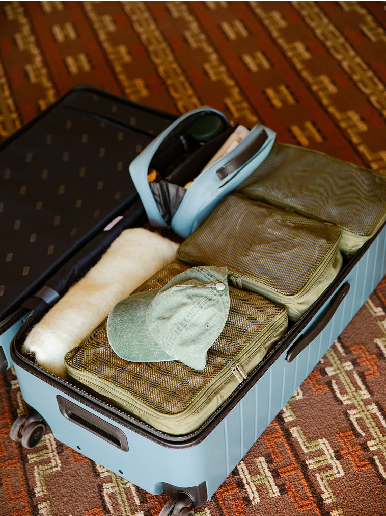 Insider Packing Cubes and Large Toiletry Bag packed inside an Away suitcase