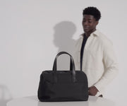 Video of a person packing the Everywhere Bag and sliding onto an Away suitcase with its trolley sleeve